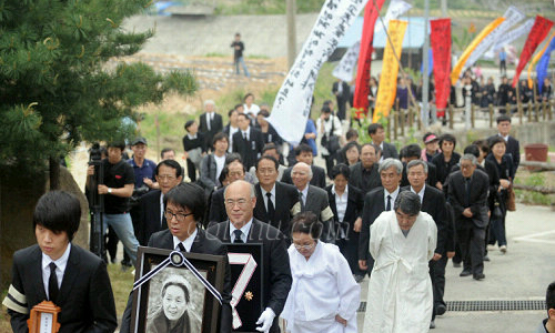 8일 토지문화관에서 열린 노제에 유가족들이 영정사진을 들고 올라가고 있다.