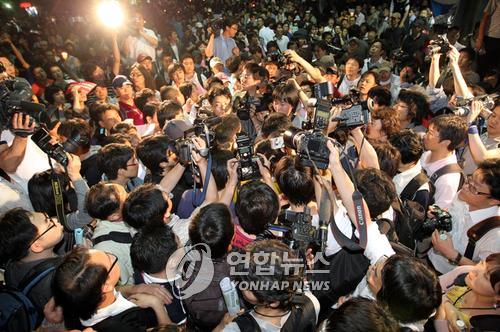 신분 조사하는 촛불대행진 시민들 (서울=연합뉴스) 이상학 기자 = 정부가 미국산 쇠고기 수입조건 고시를 발표한 29일 저녁 광화문 거리에서 촛불대행진에 참석한 시민들이 사복경찰로 오인받은 한 언론사 기자를 둘러싸고 있다.