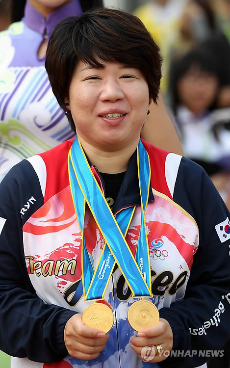(광저우=연합뉴스) 한상균 기자 = 임신 7개월의 금메달. 14일 광저우시 아오티 스포츠센터 사격장에서 열린 아시안게임 여자 공기권총 개인 10m에서 우승한 한국의 김윤미가 메달을 들어 보이고 있다. 이날 임신 7개월의 김윤미는 10m 개인, 단체에서 금메달을 획득했다. 2010.11.14 xyz@yna.co.kr