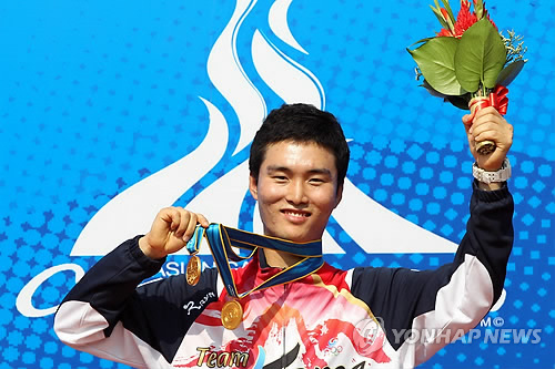 (광저우=연합뉴스) 한상균 기자 = 14일 광저우시 아오티 스포츠센터 사격장에서 열린 아시안게임 남자 개인 공기권총 10m에서 우승한 이대명이 시상대에서 메달을 들어보이고 있다. 이대명은 공기권총 단체 10m와 50m에서도 우승해 삼관왕에 올랐다. 2010.11.14 xyz@yna.co.kr