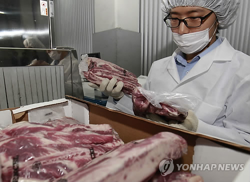 지난 27일 경기도 용인의 한 냉장 물류센터에서 검역관들이 광우병 발생과 관련해 논란이 되고 있는 미국산 쇠고기를 검사하고 있는 모습.(자료사진)