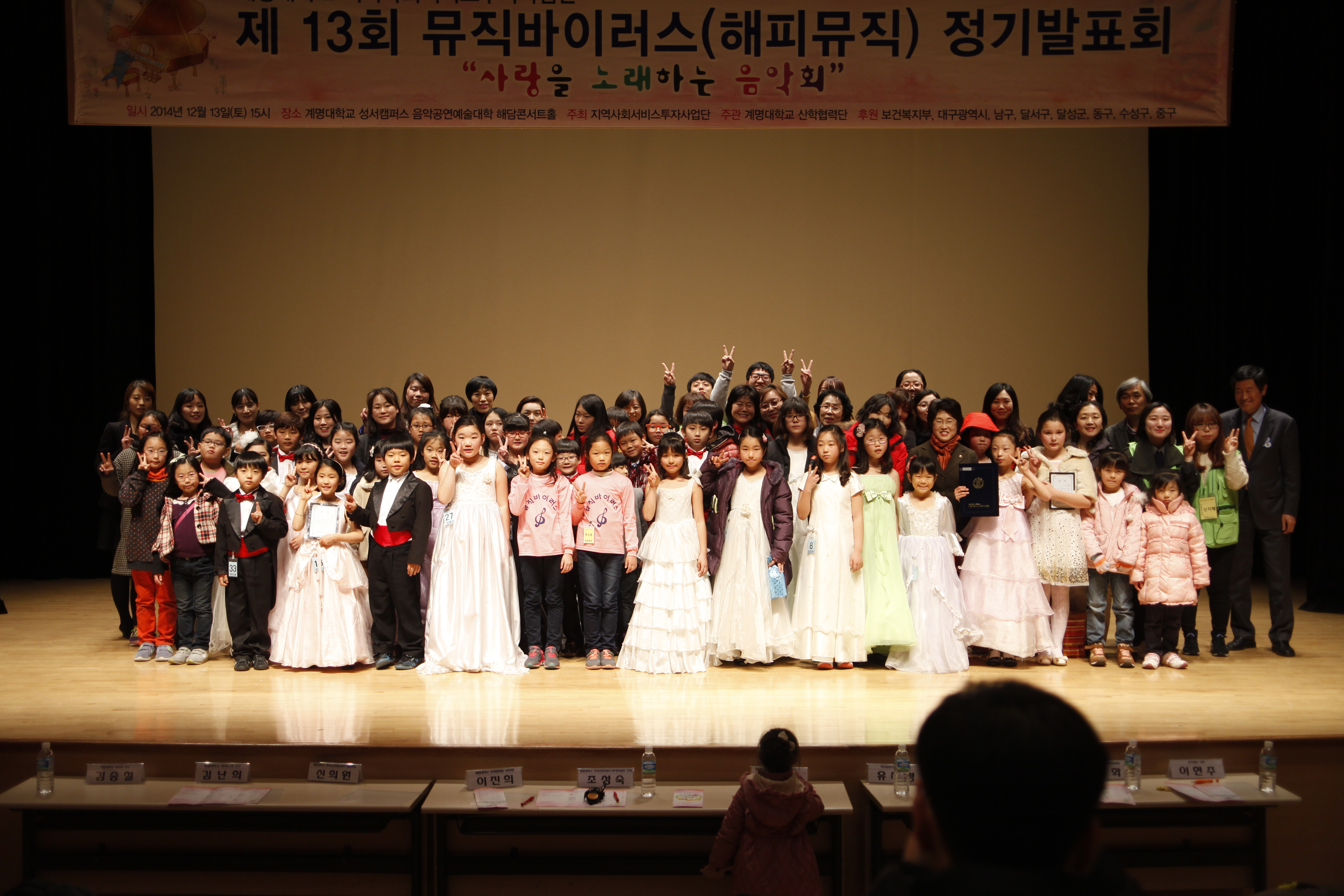 뮤직바이러스 수혜아동, 직원 등이 지난해 12월 해담콘서트홀에서 정기발표회 후 기념촬영을 하고 있다 지역사회 서비스 투자사업단