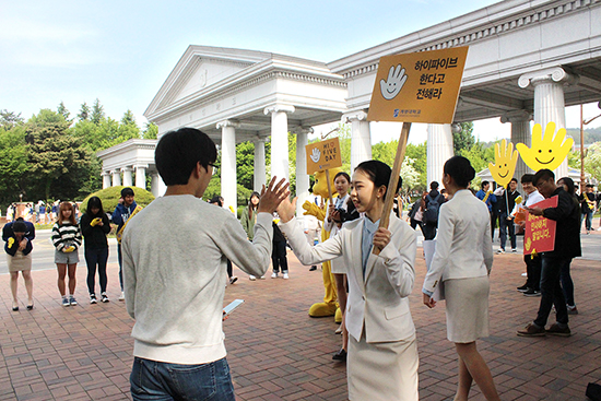 지난 4월 25일 성서캠퍼스 정문에서 진행된 ‘하이파이브 데이’ 행사에 참여한 아리미와 등교 중인 학생이 서로 하이파이브를 하며 인사하고 있다 이연희 기자